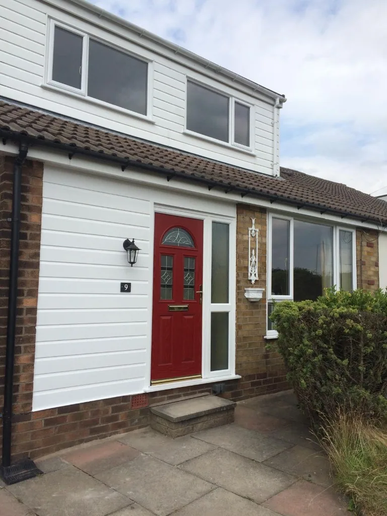 Red composite front door with sidelight and white uPVC windows