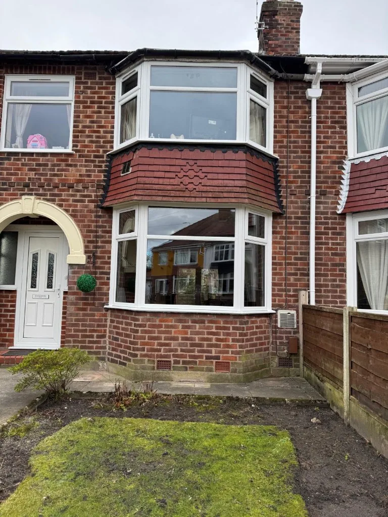 White uPVC two-storey bay windows on red brick house