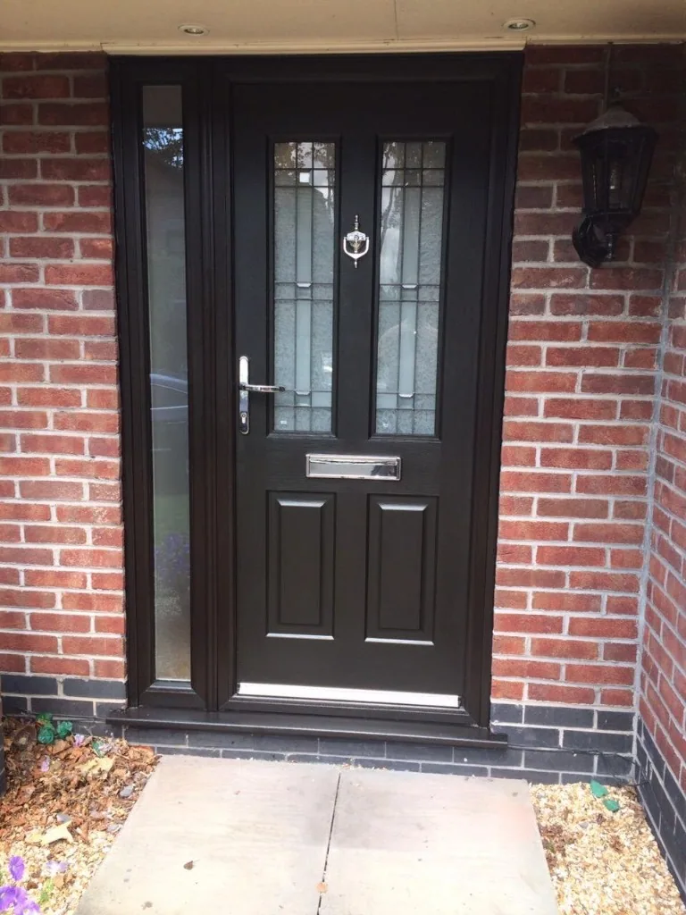 Black composite front door with side panel and chrome hardware