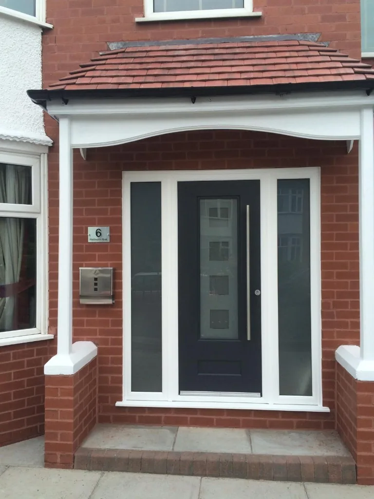 Anthracite composite front door with glazed sidelights under porch
