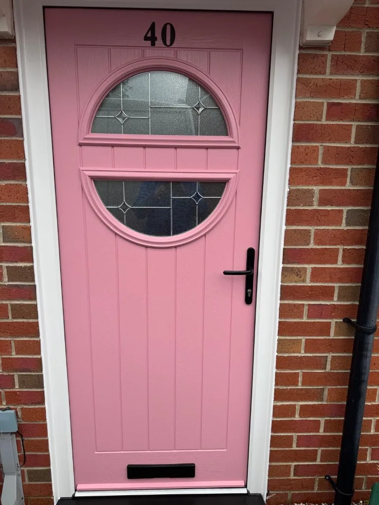 Pink cottage-style composite front door with circular glazing